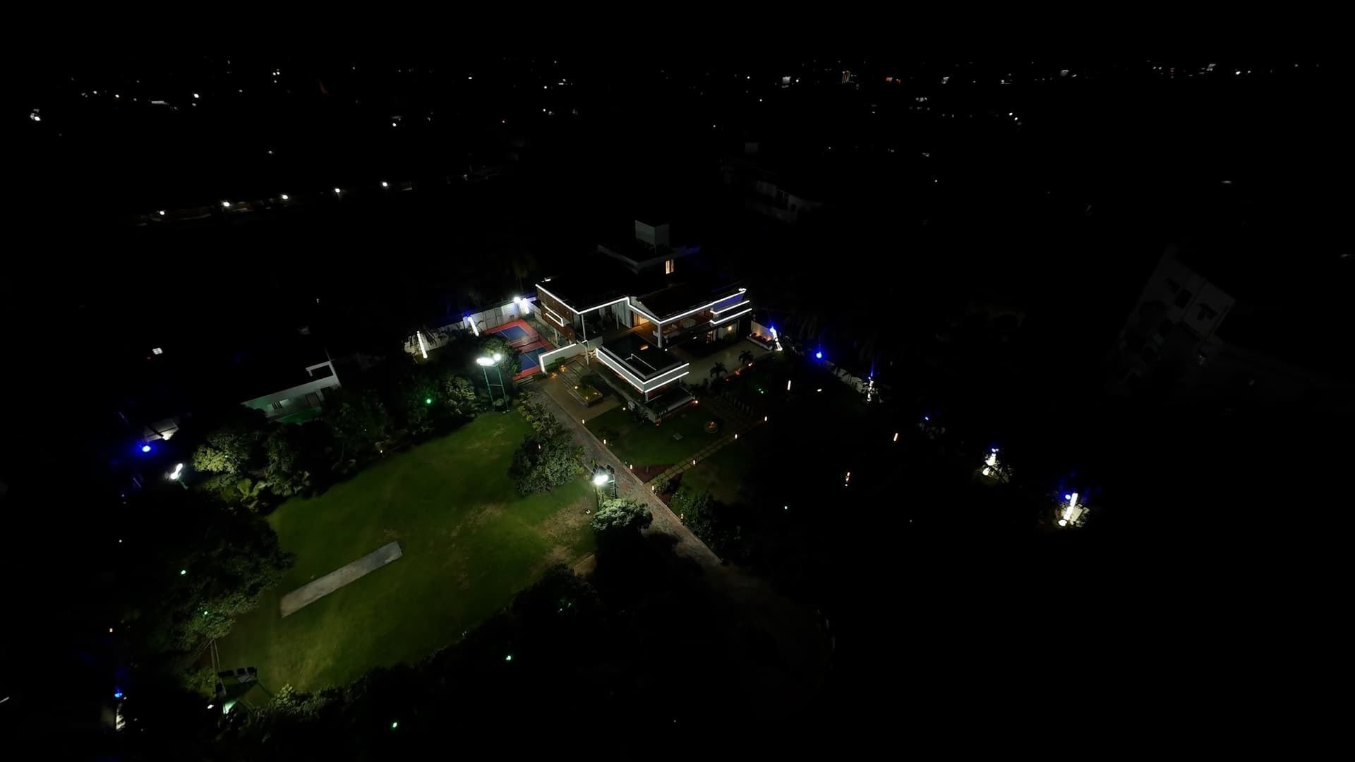 Cricket ground and pickleball court lit up for evening play.